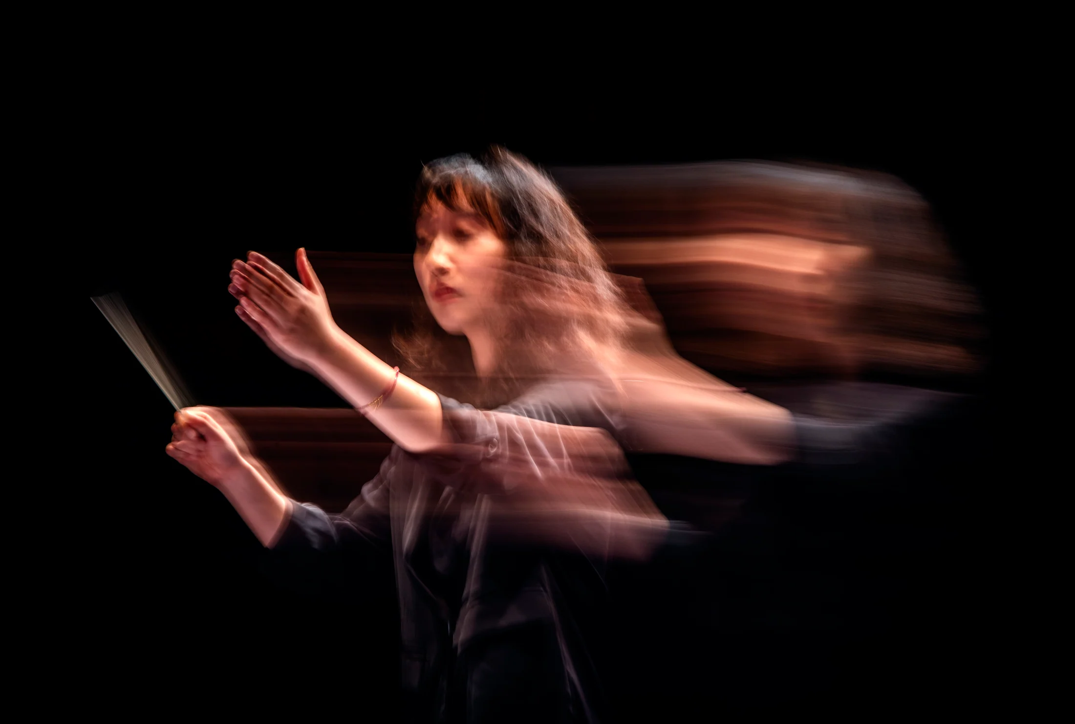 Peiwen Zou conducting, captured in motion